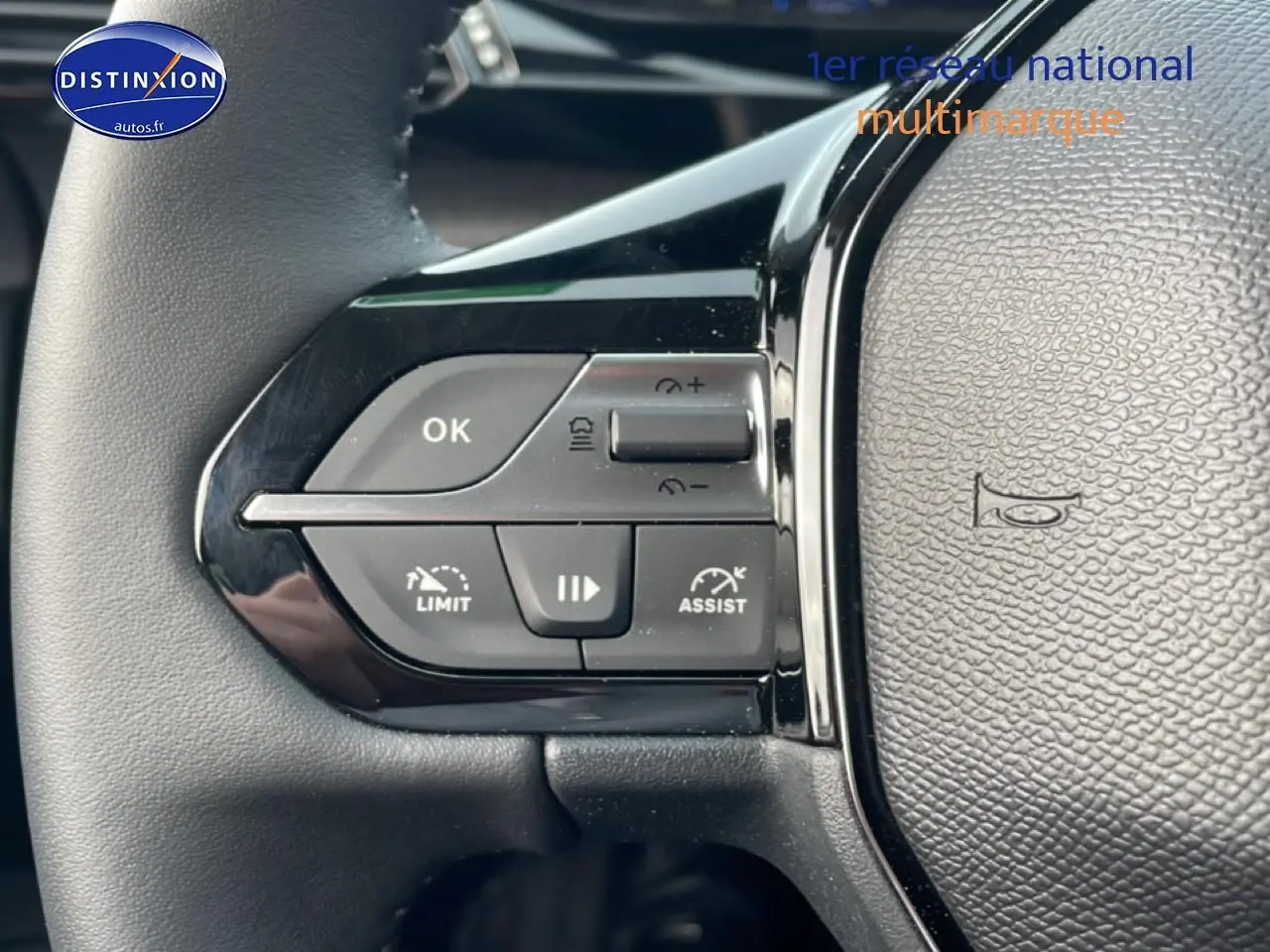 Gros plan sur les commandes gauche du volant noir de la Peugeot 308 1.2 hybrid 145 allure e-dcs6 2025.