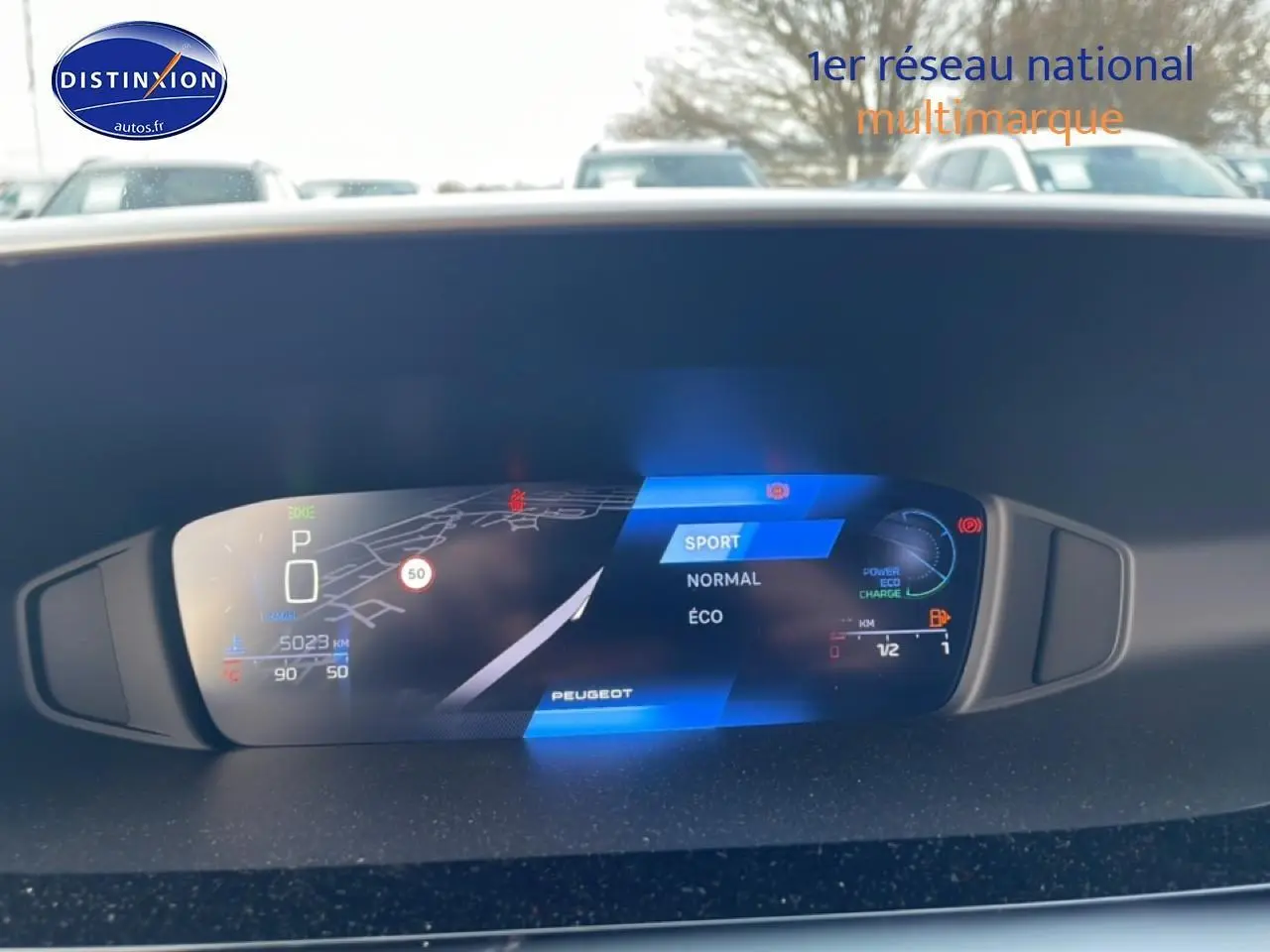 Tableau de bord numérique du Peugeot 308 hybride 2025 affichant modes de conduite et navigation.