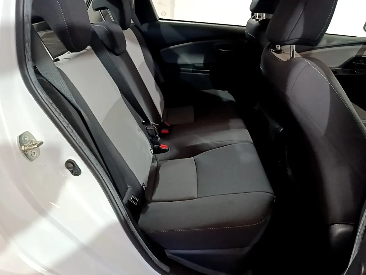 Vue intérieure côté gauche montrant la banquette arrière bicolore gris et noir de la Toyota Yaris 1.5 Hybride 2020 blanche.