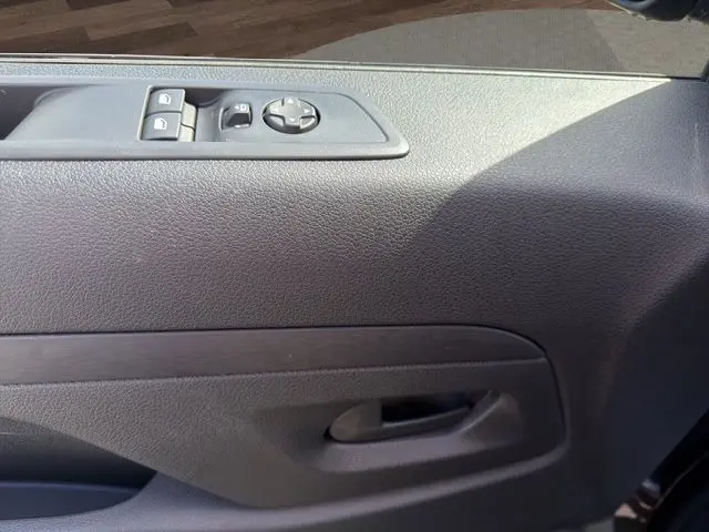 Détail de la porte intérieure côté conducteur du Citroën Jumpy gris titane, avec commandes électriques des vitres et rétroviseurs.