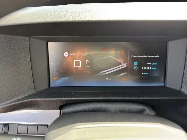 Combiné numérique affichant la vitesse et la consommation instantanée dans un Citroën Jumpy gris titane, vue intérieure tableau de bord.