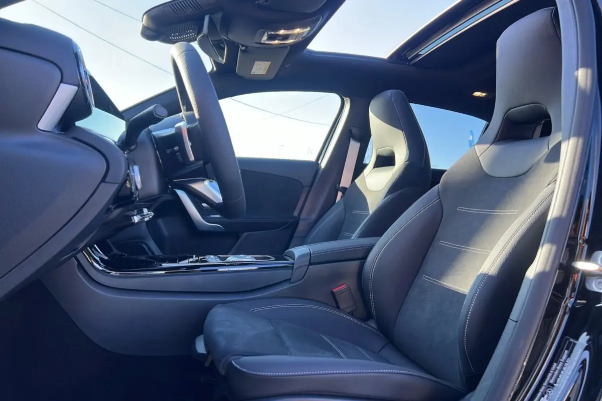 Intérieur noir de la Mercedes Classe A 200D BVA Exclusive Design vu côté conducteur, avec sièges sport et toit ouvrant panoramique.