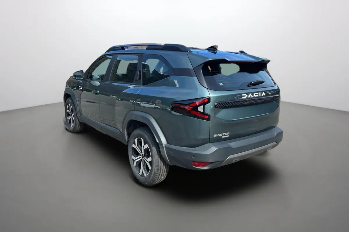 Vue 3/4 arrière droite du Dacia Bigster Hybrid 155 Expression Plus vert cèdre avec barres de toit et jantes alu 17 pouces.