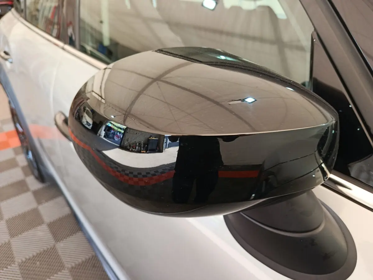 Rétroviseur noir brillant côté gauche d'une MINI Countryman gris foncé, vue rapprochée en intérieur.