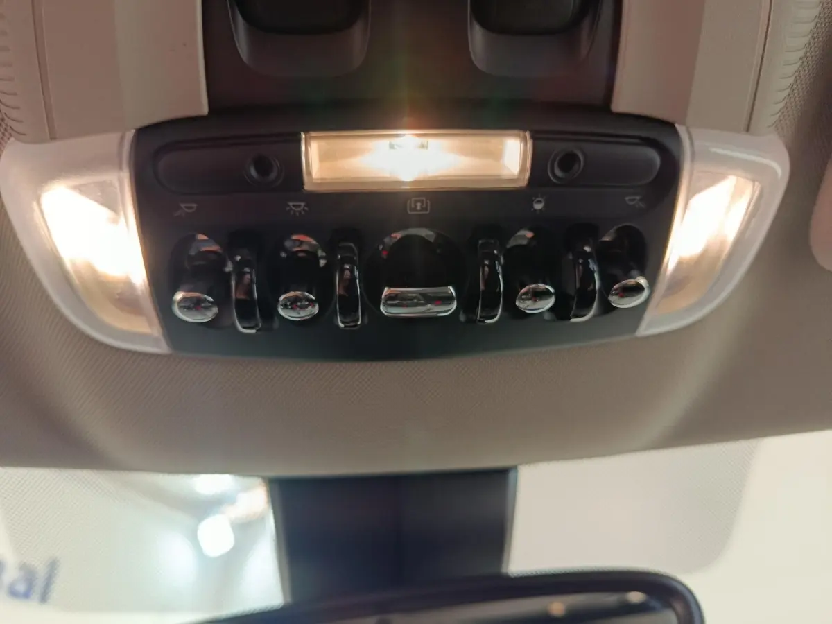 Vue intérieure en gros plan du panneau de commandes de plafonnier avec éclairage, dans un MINI Countryman gris foncé 2023.