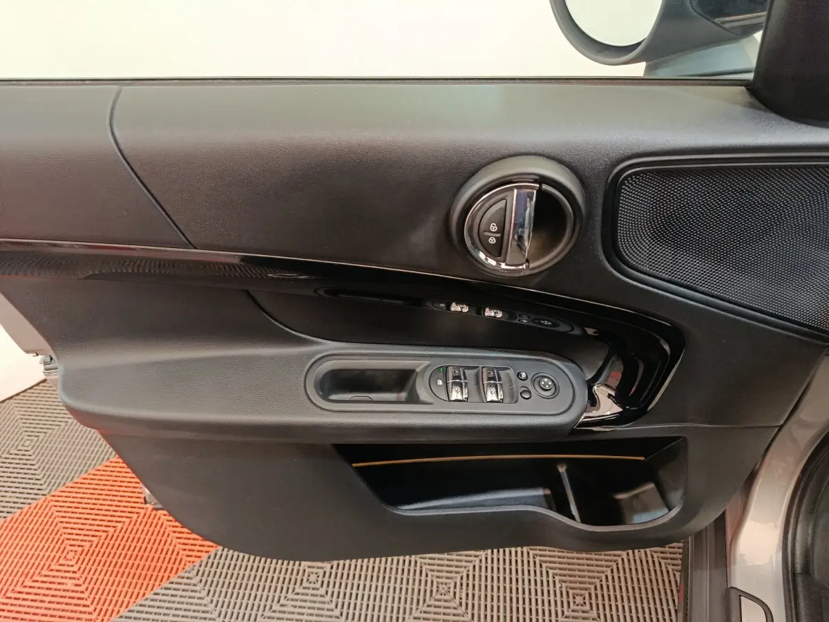 Vue rapprochée de la porte côté conducteur du MINI Countryman gris foncé, avec commandes de vitres et verrouillage intégrées.