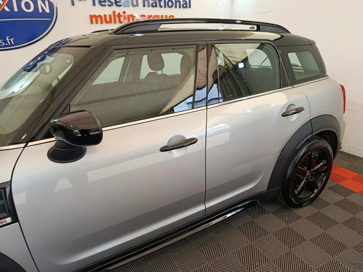 Vue latérale droite d'une MINI Countryman gris foncé avec toit noir et jantes noires brillantes.