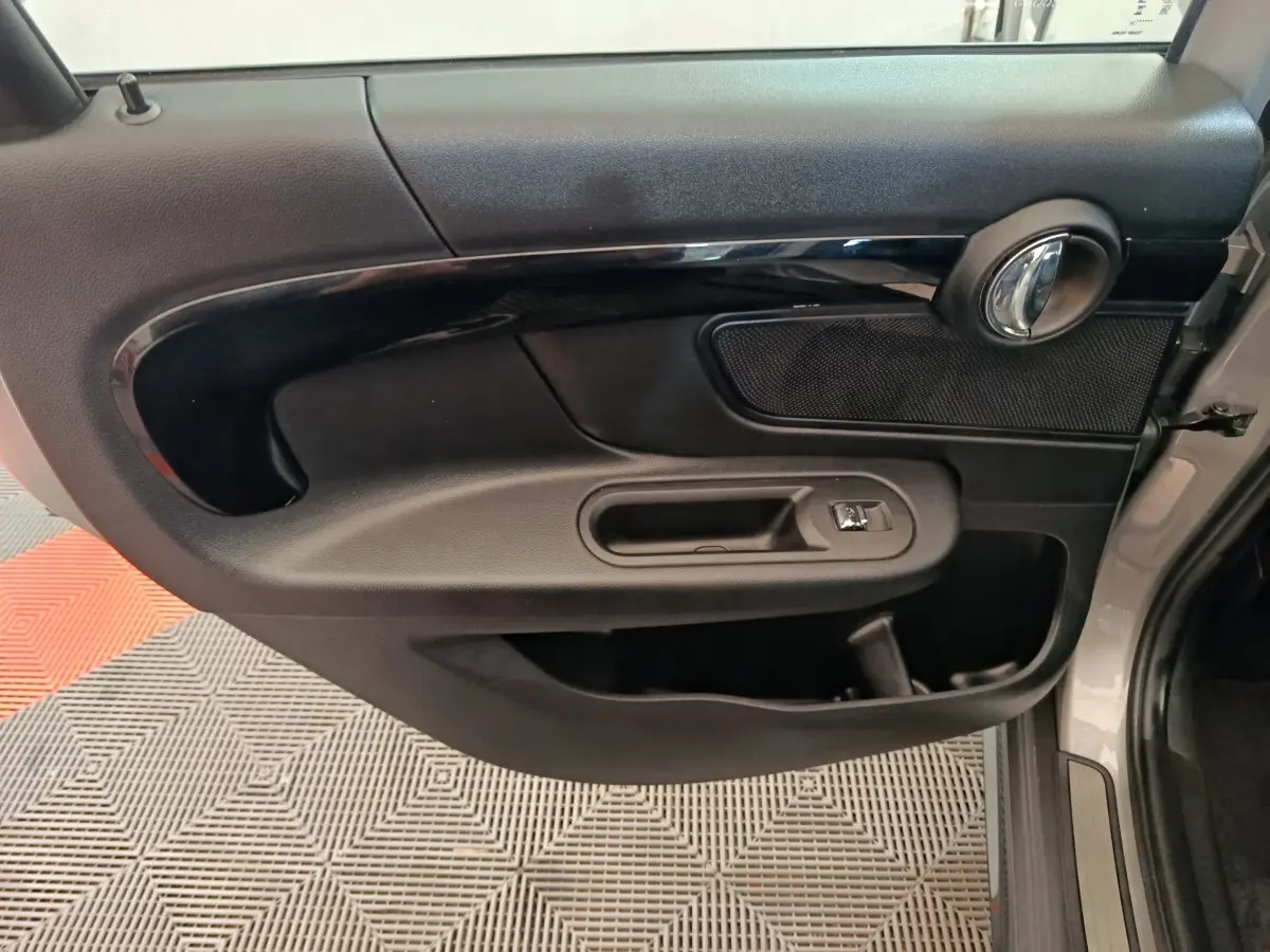 Vue rapprochée de la porte avant droite noire intérieure du MINI Countryman gris foncé 2023 avec poignée chromée.