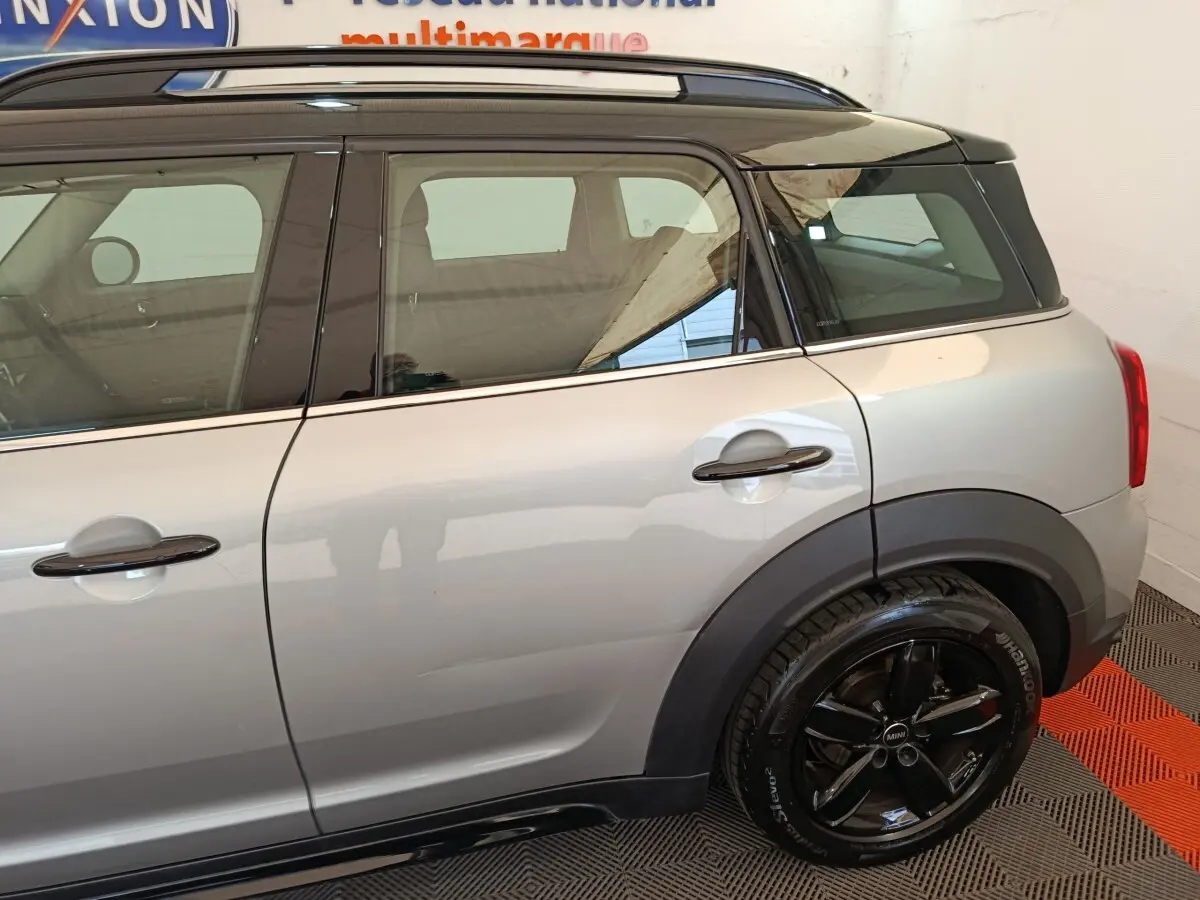 Vue latérale droite d'un MINI Countryman gris foncé avec toit noir et jantes noires brillantes.