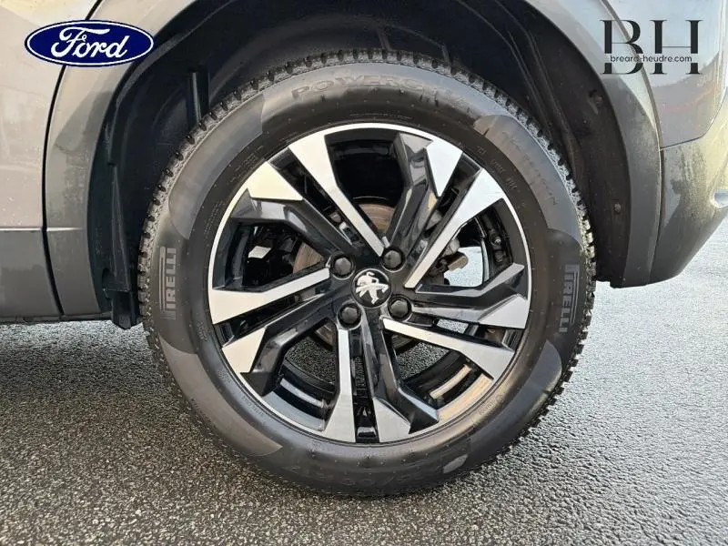 Gros plan sur la roue avant droite du Peugeot 2008 gris Artense, avec jante alliage noire et argentée distinctive.