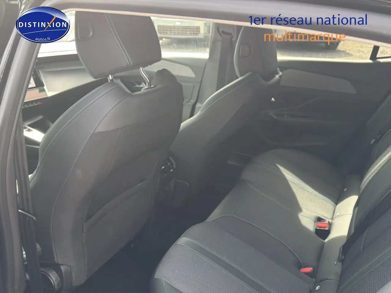 Vue intérieure arrière côté droit de la Peugeot 408 Hybrid 136 allure e-dcs6 noire, sièges en tissu et cuir avec surpiqûres contrastées.