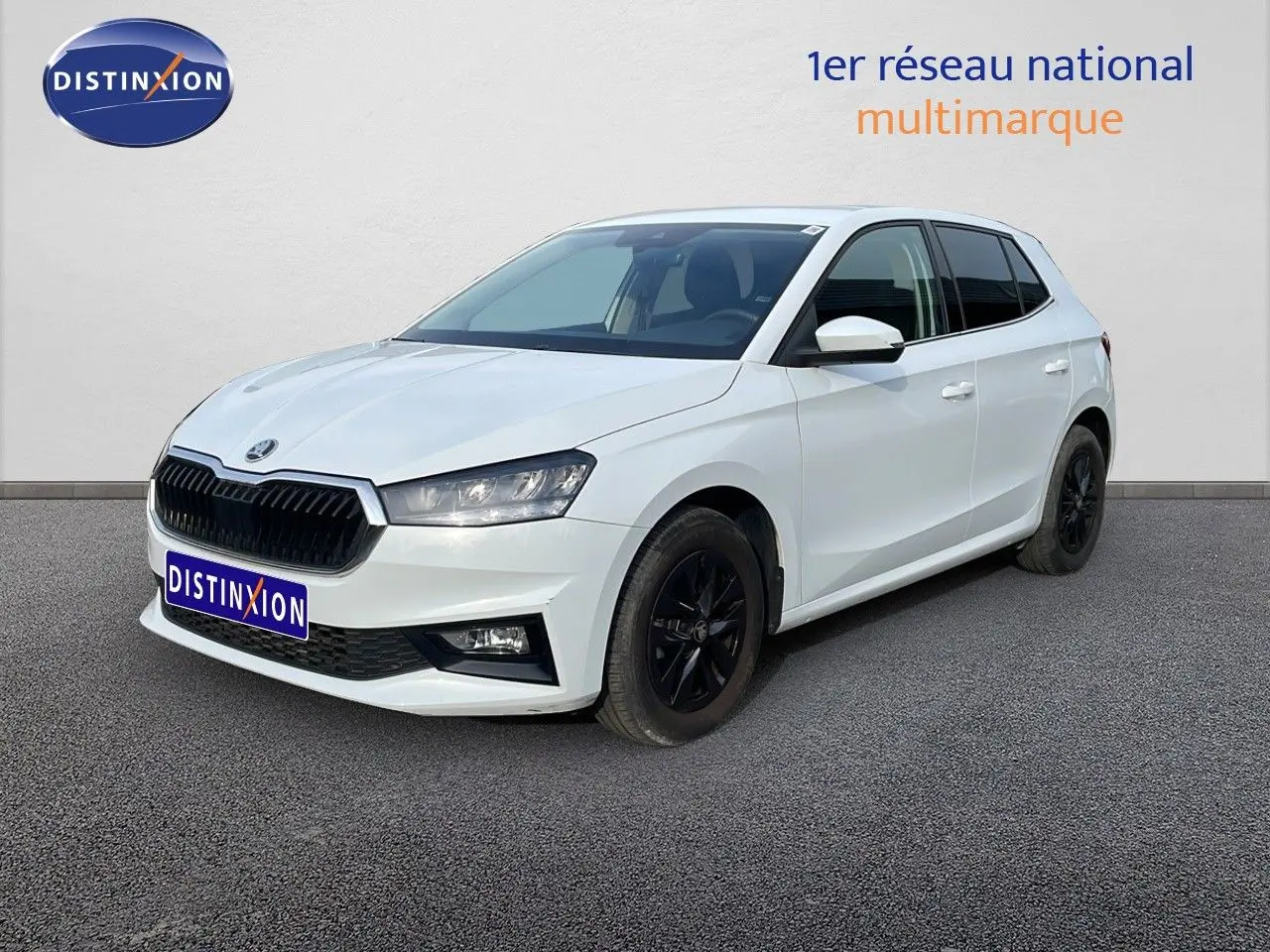 Vue 3/4 avant droite d'une Skoda Fabia blanc glacier avec jantes noires et calandre noire distinctive.