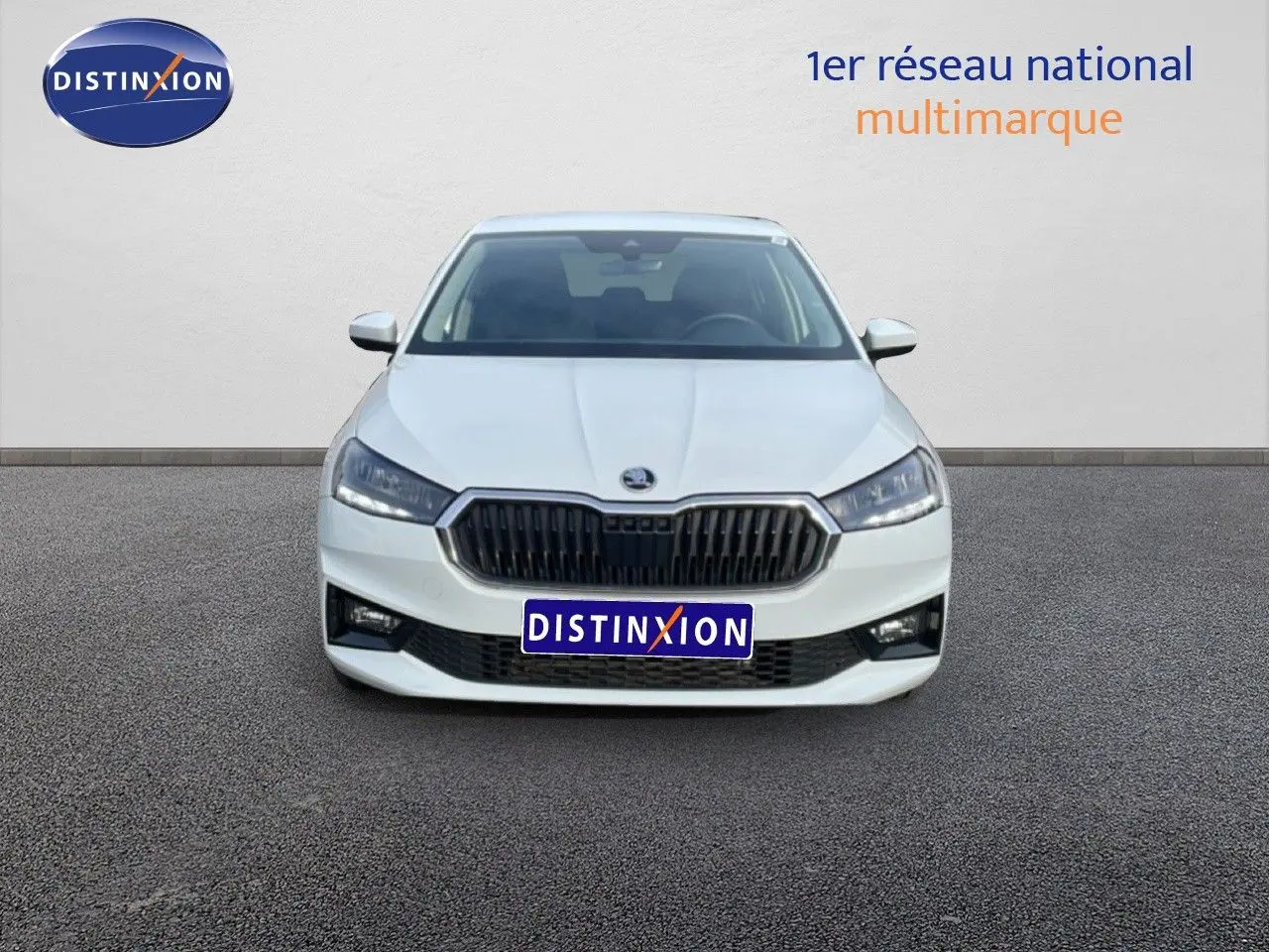 Vue frontale d'une Skoda Fabia blanche glacier 2025 avec calandre noire et phares LED allumés.