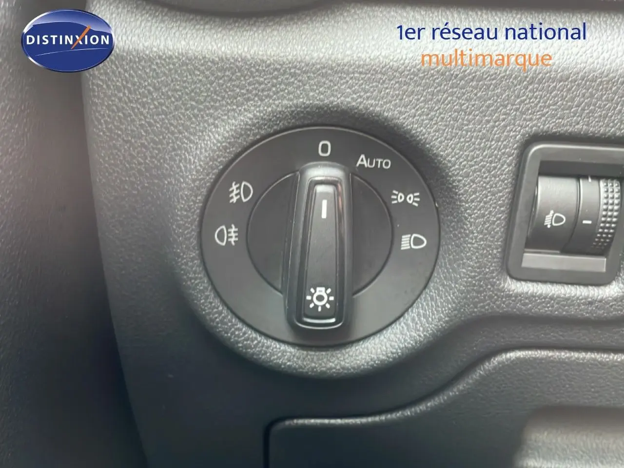 Gros plan sur le bouton de commande des phares dans l’habitacle d’une Skoda Fabia blanc glacier 2025.