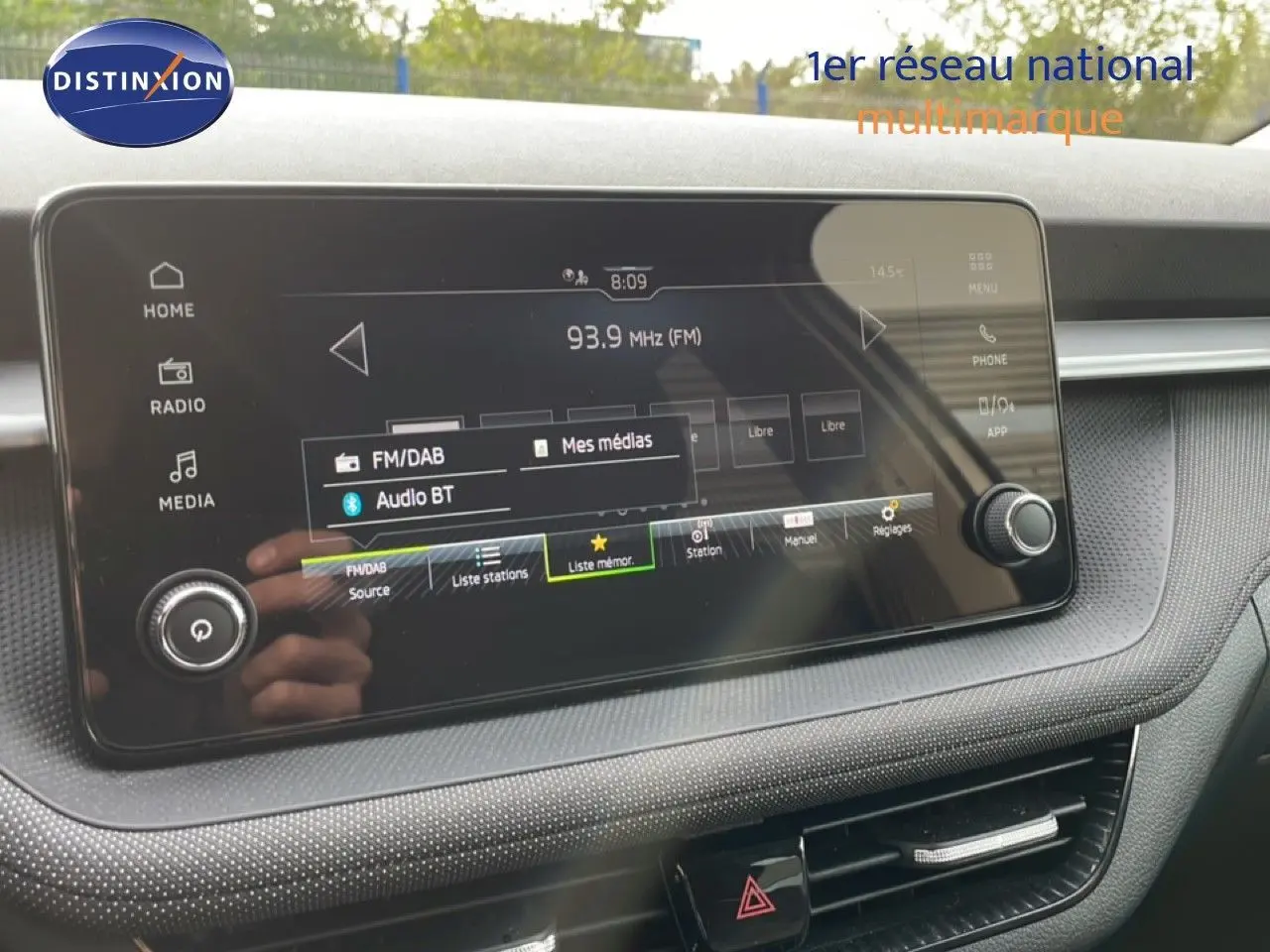 Écran tactile central du tableau de bord de la Skoda Fabia blanc glacier, affichant la radio FM à 93,9 MHz.