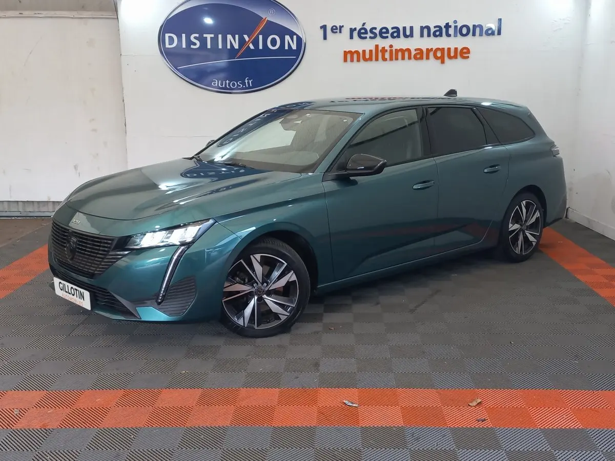 Peugeot 308 break bleu en 3/4 avant droit, avec jantes alliage et phares LED distinctifs.
