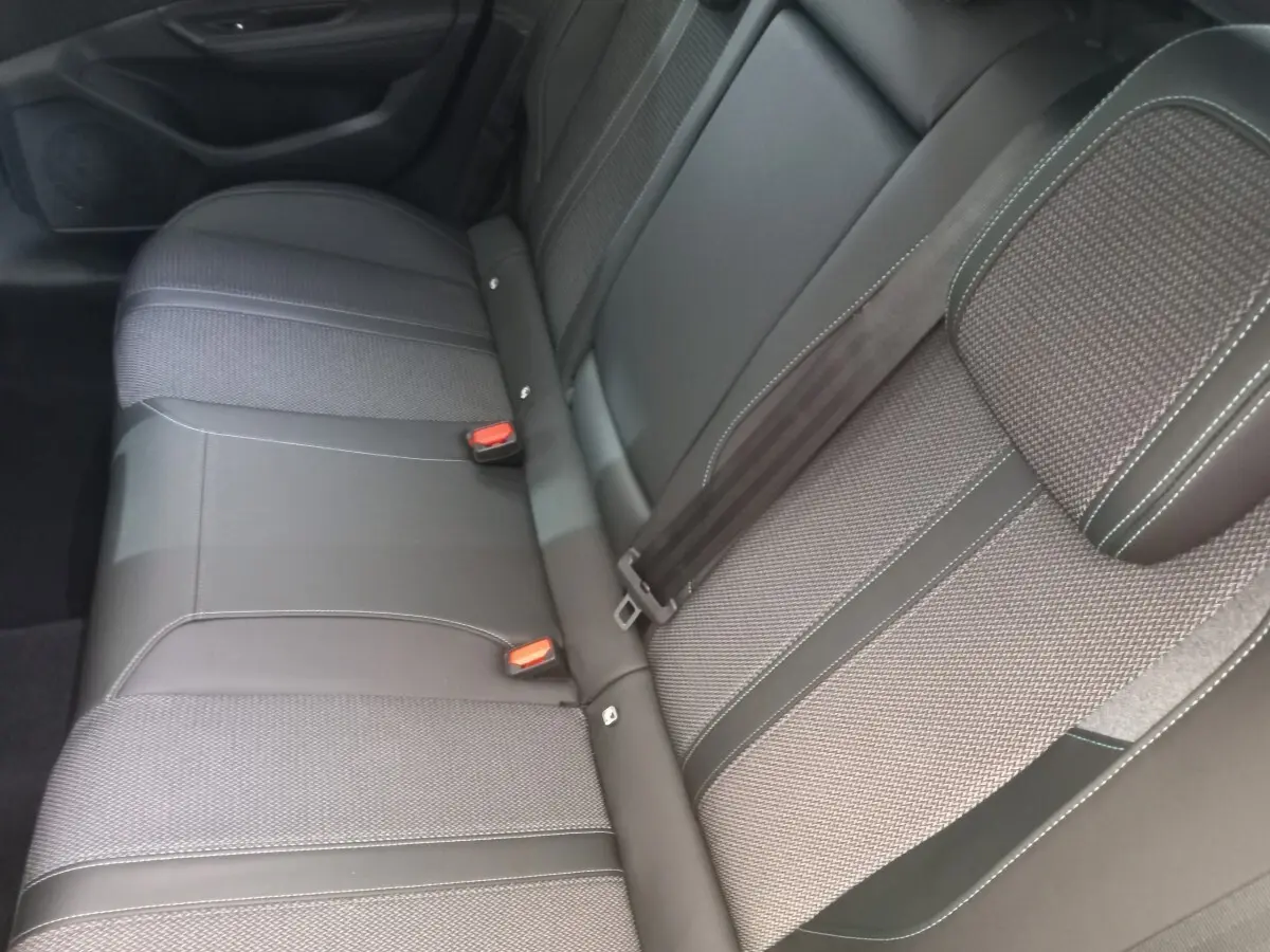 Vue rapprochée de la banquette arrière grise et noire de la Peugeot 308 PureTech 130, avec ceintures et appuie-tête visibles.