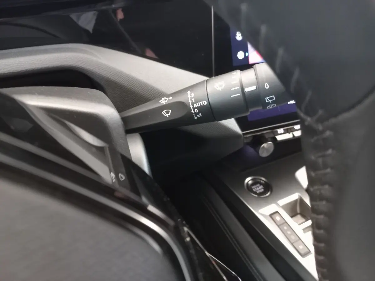Détail intérieur du Peugeot 308 PureTech 130, montrant la commande d’essuie-glace et le bouton de démarrage, côté conducteur.
