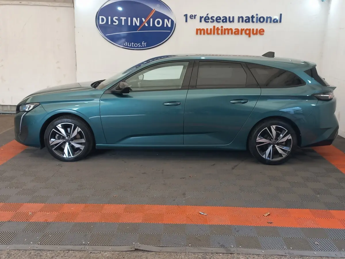 Peugeot 308 PureTech 130 bleu vue de profil côté gauche, avec jantes alliage et vitres teintées.