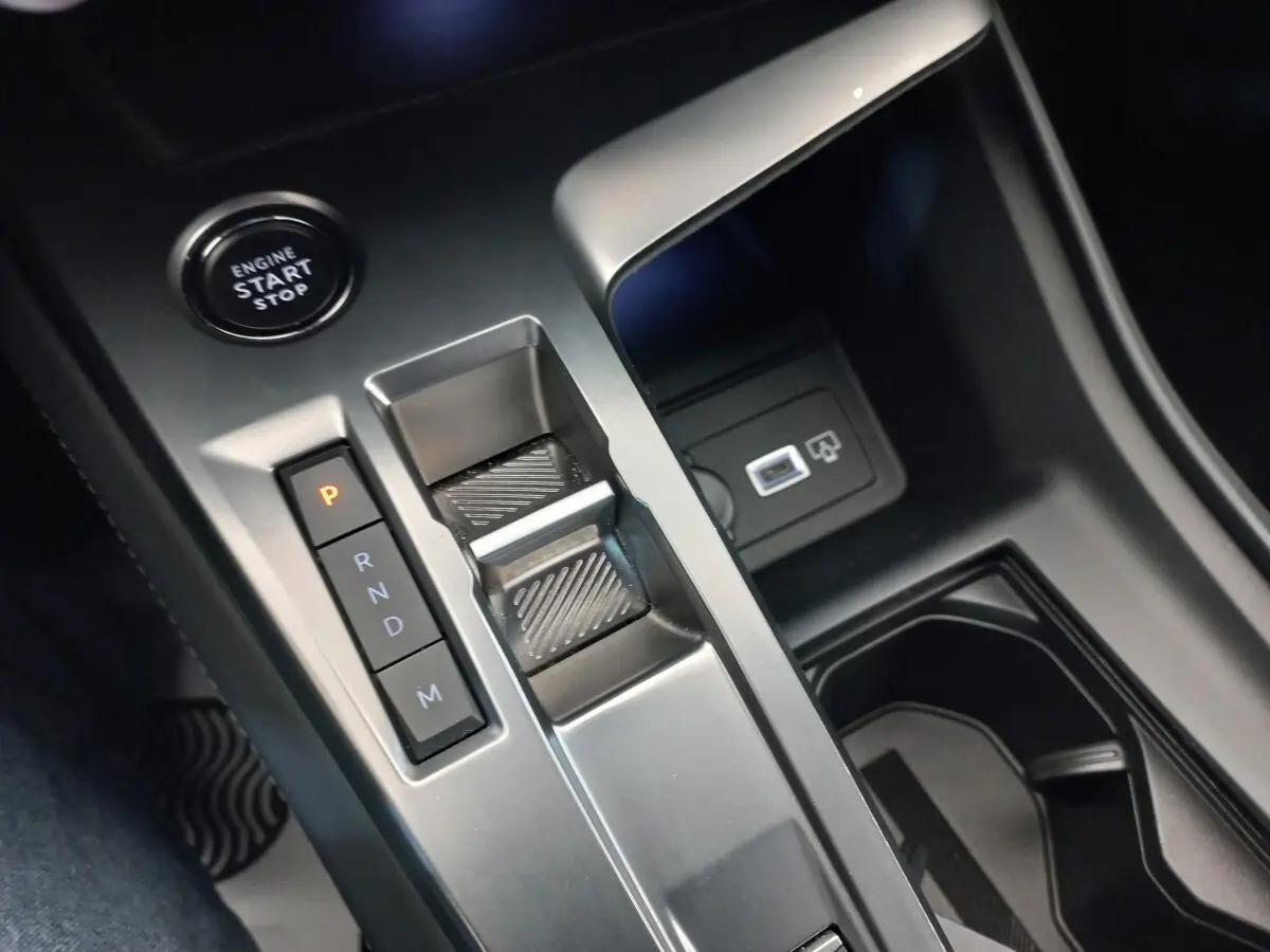 Gros plan sur la console centrale de la Peugeot 308 bleu, montrant la commande de boîte auto et le bouton start/stop.