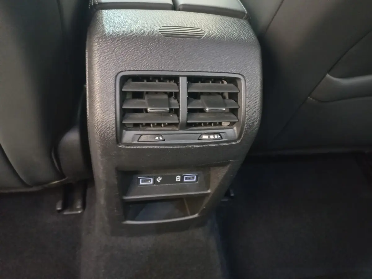 Gros plan sur la console arrière noire de la Peugeot 308 avec bouches d’aération et ports USB visibles.