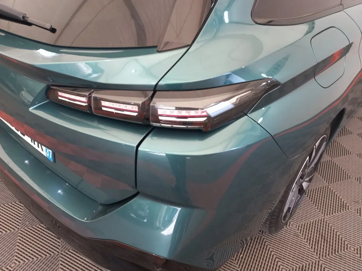 Vue 3/4 arrière droite d'une Peugeot 308 bleu métallisé avec feux arrière LED distinctifs et jante alliage.