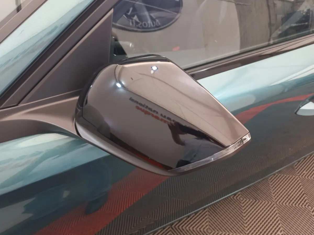 Rétroviseur droit noir brillant de la Peugeot 308 bleu, vue rapprochée sur la portière côté droit.
