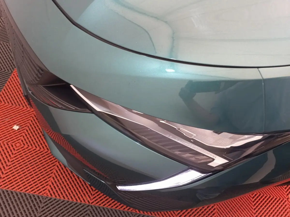 Gros plan sur le phare avant gauche bleu métallisé de la Peugeot 308 PureTech 130 avec détails LED et design anguleux.