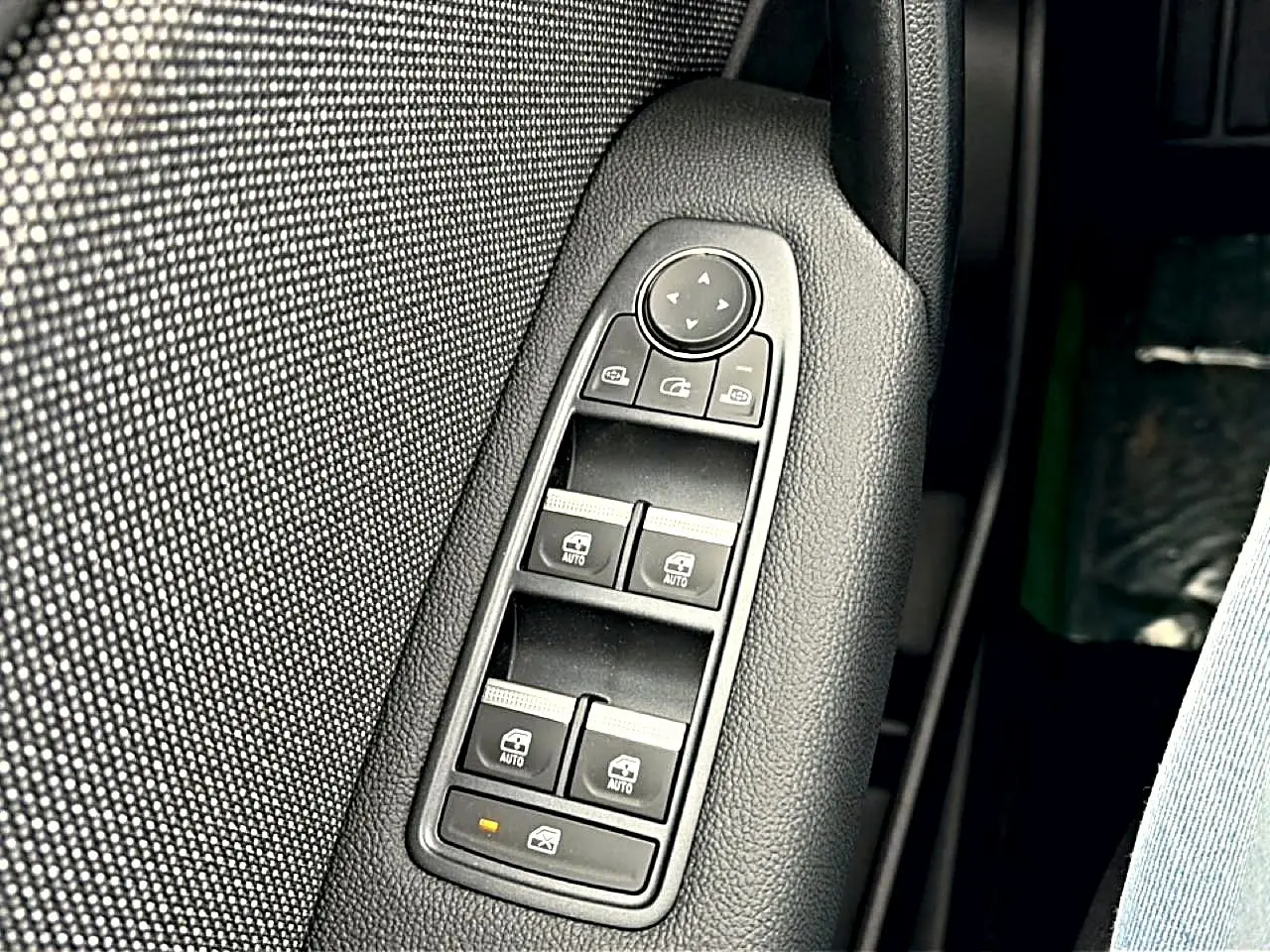Gros plan sur les commandes des vitres électriques et rétroviseurs sur la porte côté conducteur du Renault Symbioz 2026.