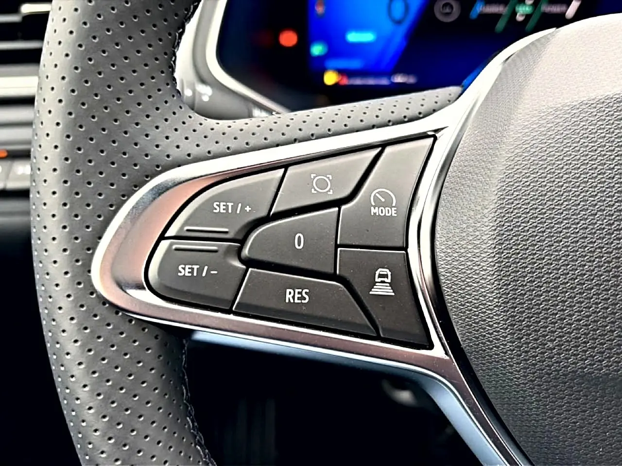 Gros plan sur les commandes de régulateur de vitesse au volant perforé du Renault Symbioz bleu mercure, intérieur moderne.