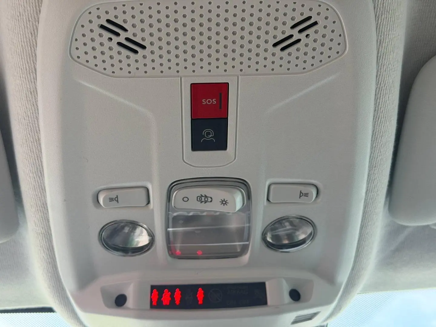Vue en gros plan du plafonnier blanc avec boutons SOS et éclairage intérieur de la Peugeot 208 hybride 2025.