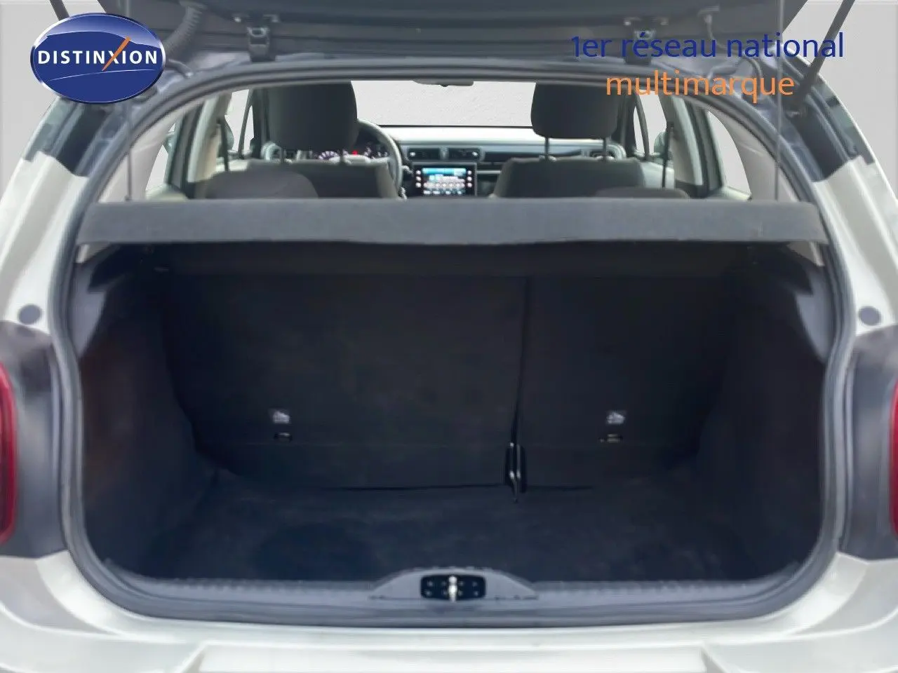 Vue arrière du coffre ouvert d'une Citroën C3 sable métal 2022, montrant l'intérieur spacieux et la tablette arrière.