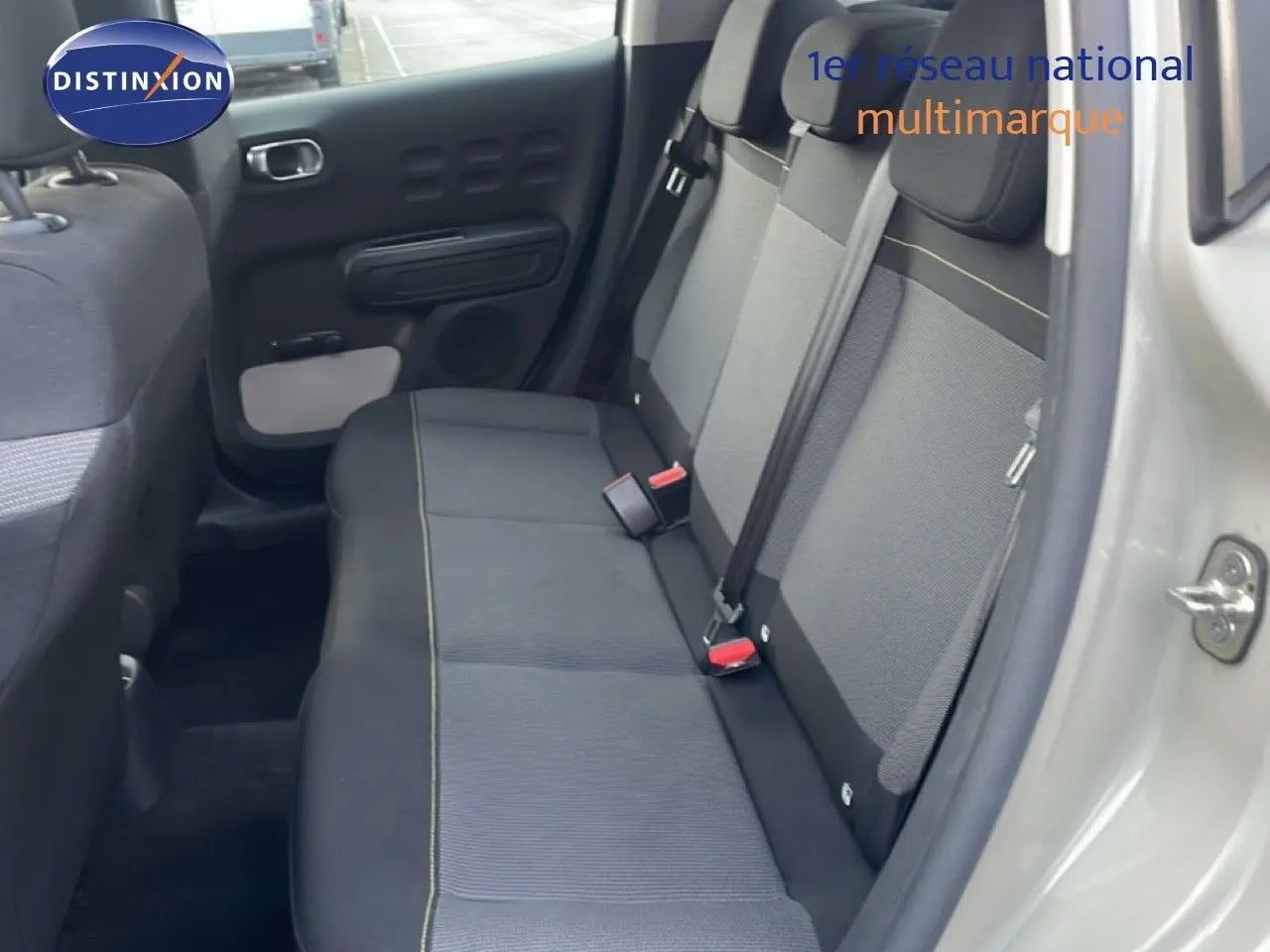 Vue intérieure côté droit montrant la banquette arrière en tissu gris avec surpiqûres jaunes d'une Citroën C3 sable métal 2022.