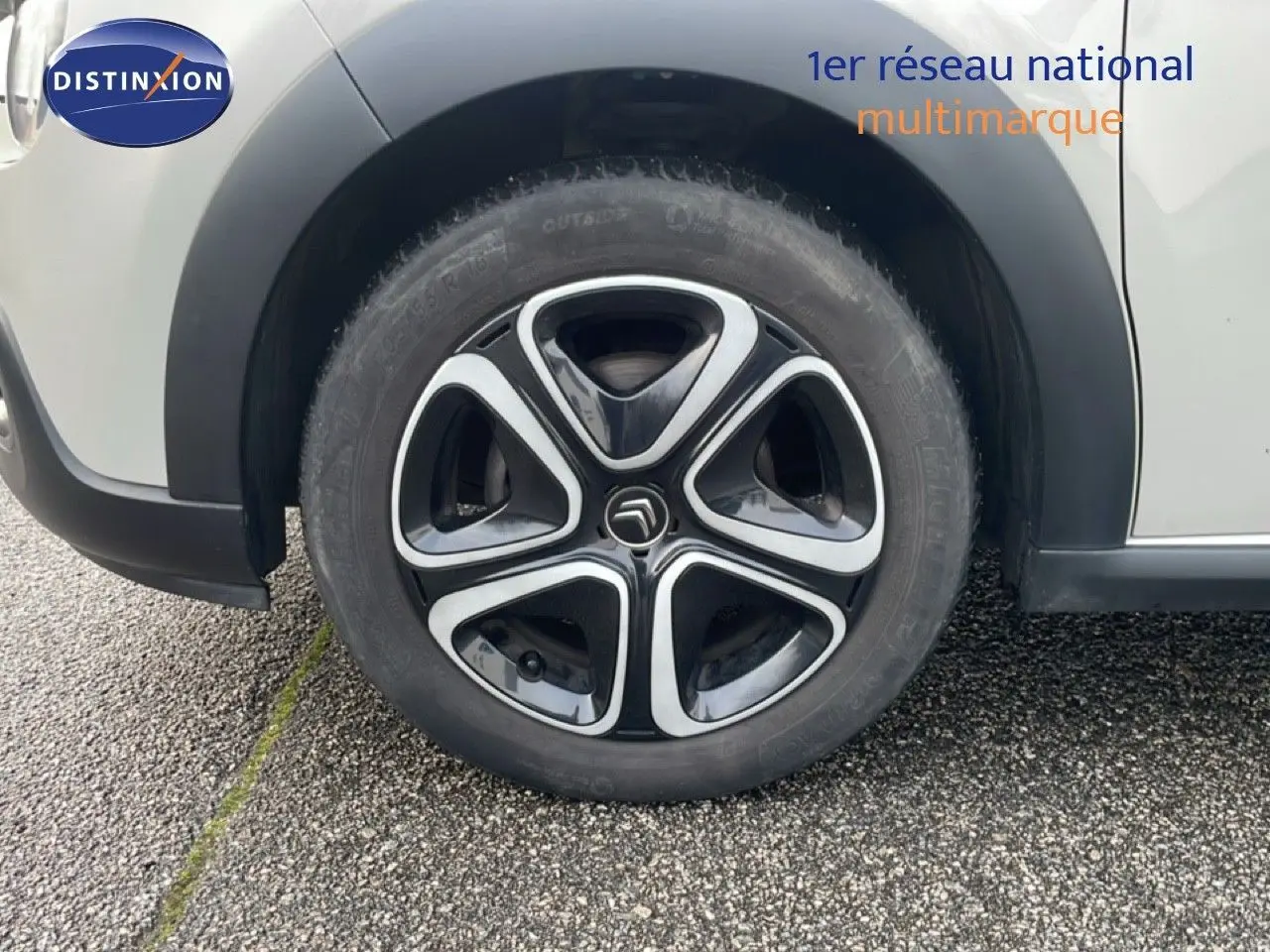 Gros plan sur la roue avant gauche d'une Citroën C3 sable métal, mettant en valeur la jante noire et argentée au design distinctif.