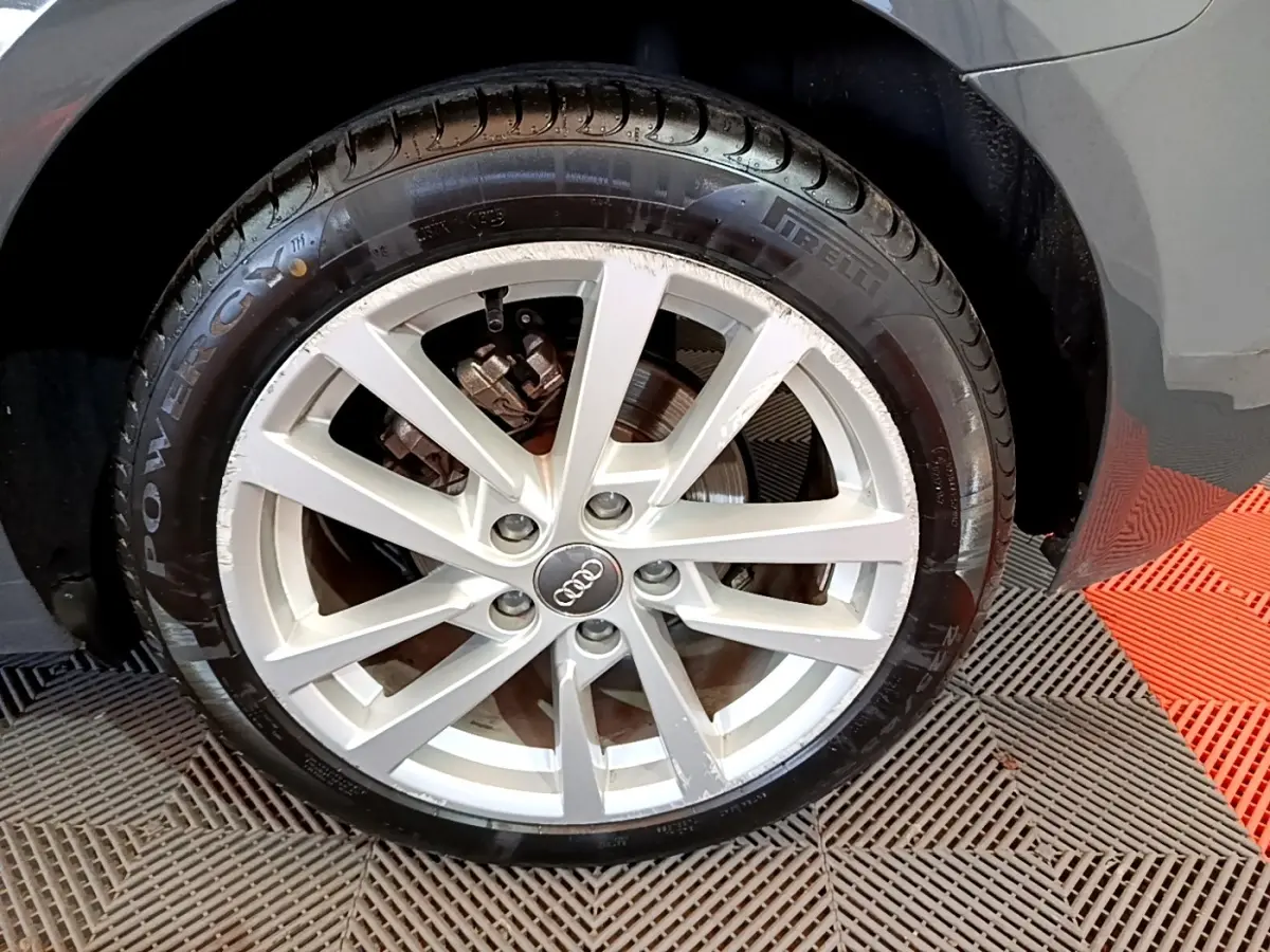 Gros plan sur la roue avant droite gris foncé d’une Audi A3 30 TDI 116 S tronic Business Line avec jante argentée.