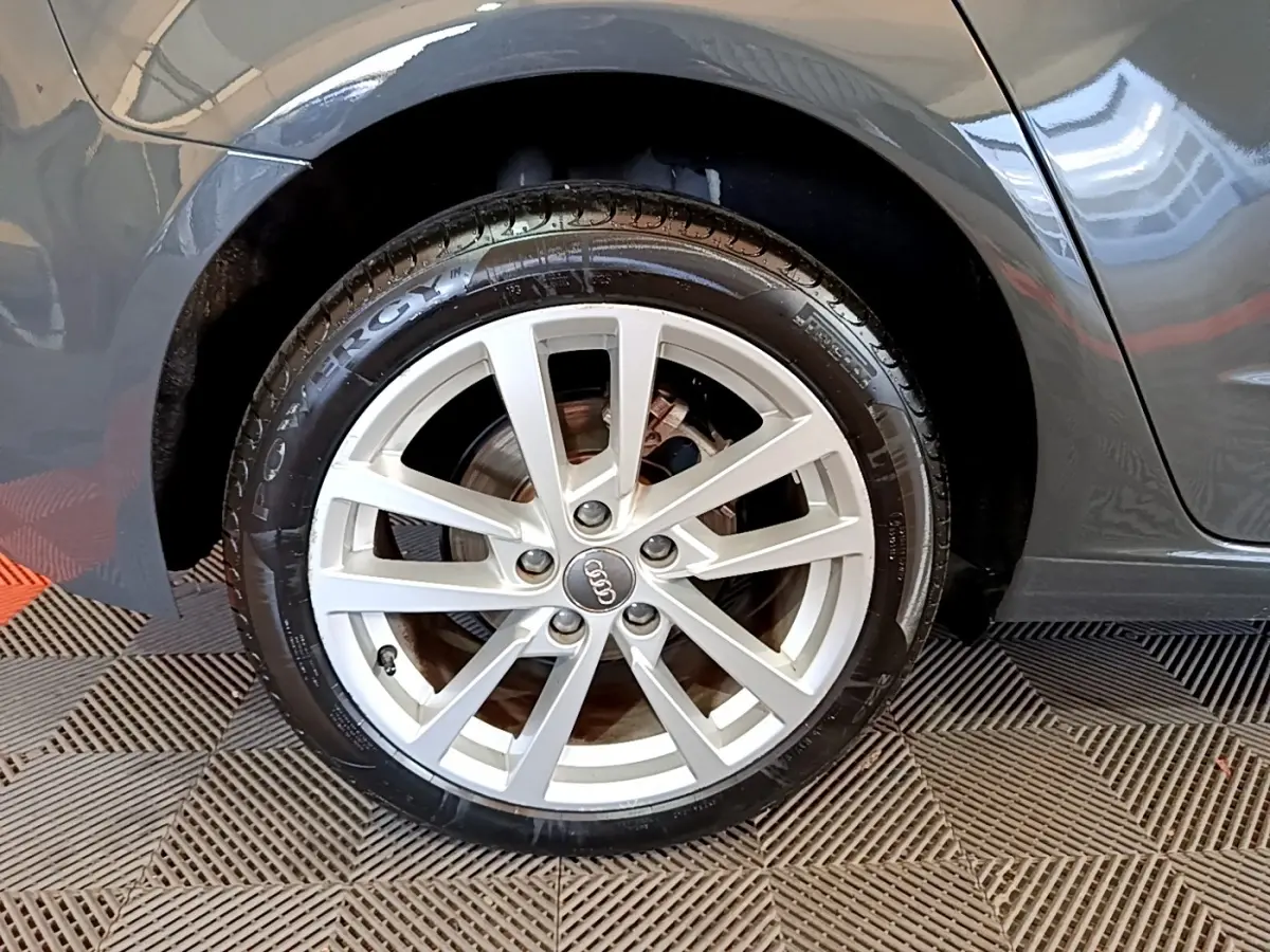 Gros plan sur la roue arrière droite gris foncé d'une Audi A3 30 TDI 116 S tronic Business Line avec jante argentée à dix branches.