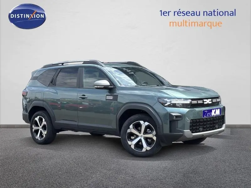 Vue 3/4 avant droite du Dacia Bigster gris avec barres de toit et jantes alliage distinctives.