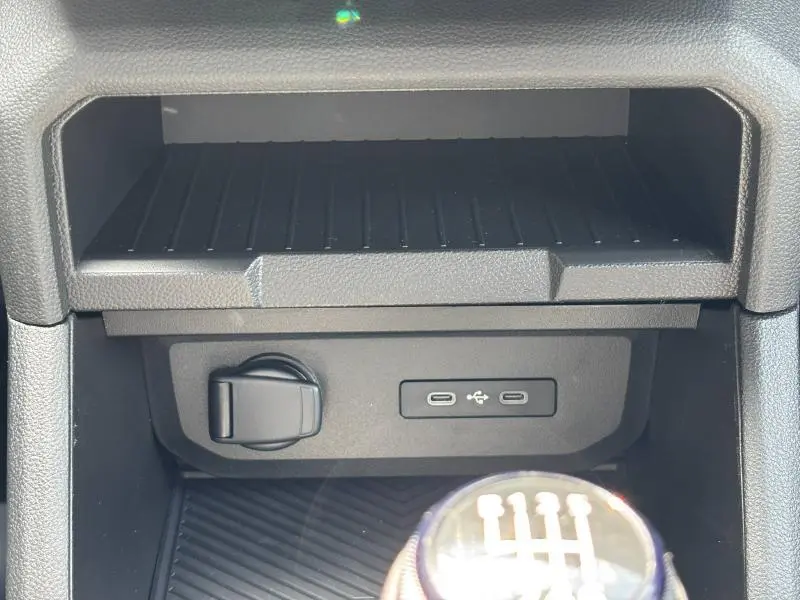 Gros plan intérieur sur la console centrale du Dacia Bigster blanc, montrant prise USB-C et levier de vitesse manuel.