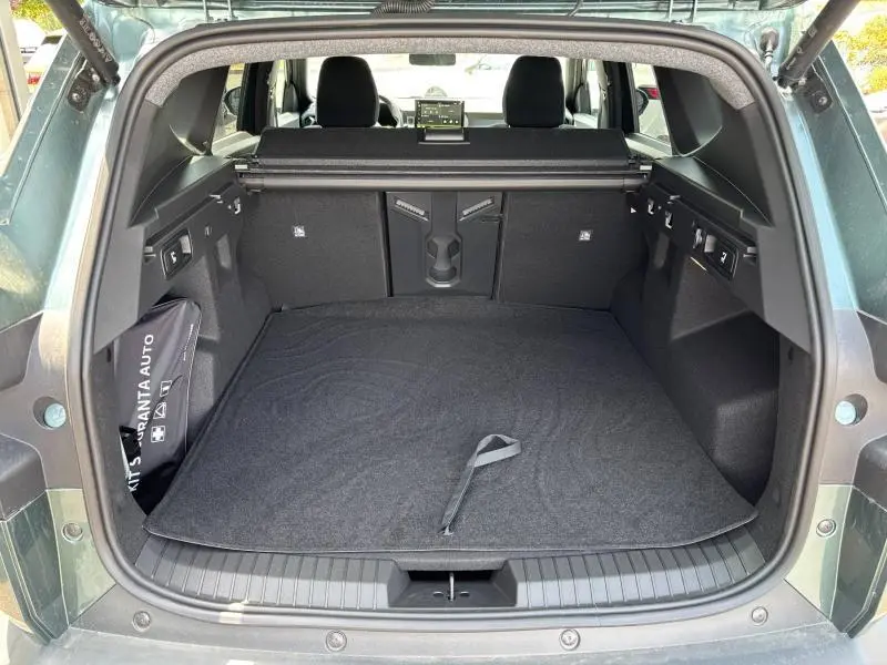 Coffre ouvert vu de l'arrière d'un Dacia Bigster blanc, montrant un espace de chargement avec tapis noir et banquette arrière.