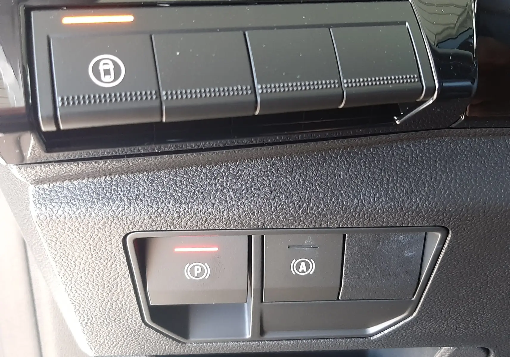 Détail des commandes intérieures noires du tableau de bord du Renault Austral E-Tech blanc nacré, avec voyants rouges allumés.
