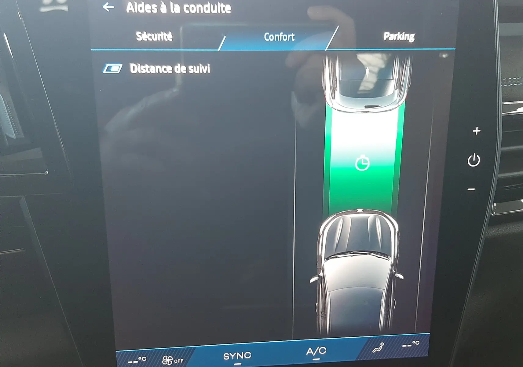 Écran central du Renault Austral 2025 montrant l'aide à la conduite avec vue du véhicule en blanc nacré sur fond noir.