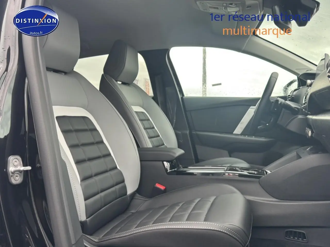 Vue intérieure côté gauche montrant les sièges avant bi-ton gris et noir de la Citroën C4 hybride 2025.