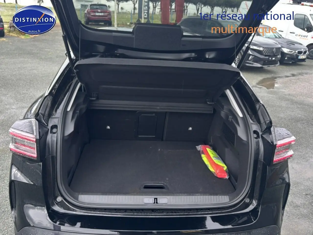 Coffre ouvert vu de l'arrière d'une Citroën C4 noire 2025 avec feux arrière LED et espace de chargement vide.