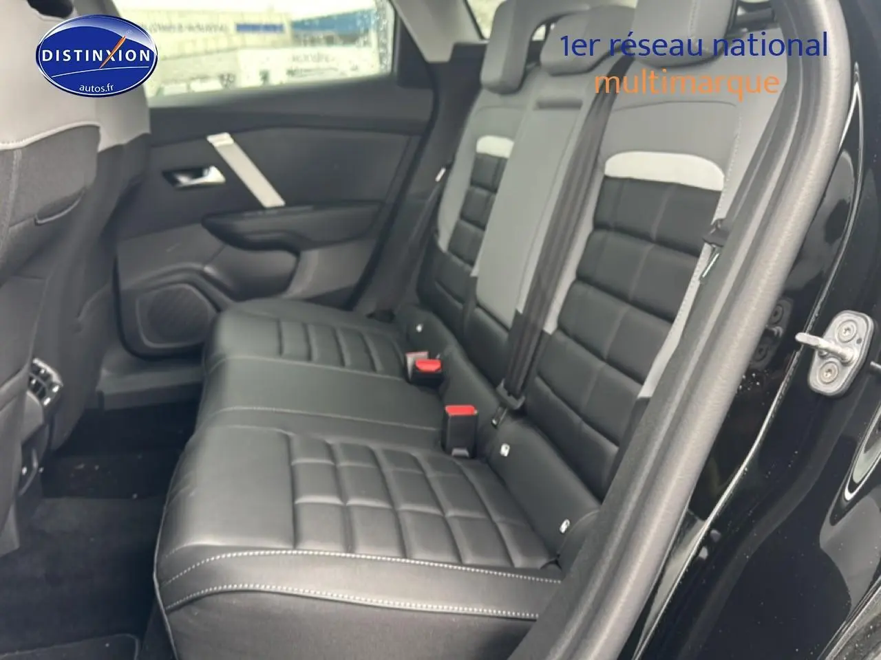 Vue intérieure côté gauche montrant la banquette arrière en cuir noir de la Citroën C4 hybride 2025 avec porte ouverte.