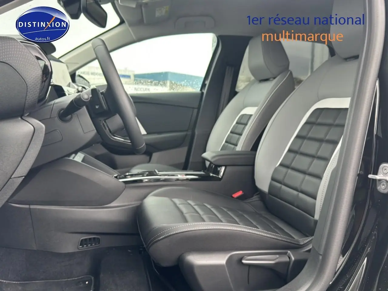 Vue intérieure côté conducteur de la Citroën C4 noire 2025, sièges bi-ton cuir noir et gris avec accoudoir central.