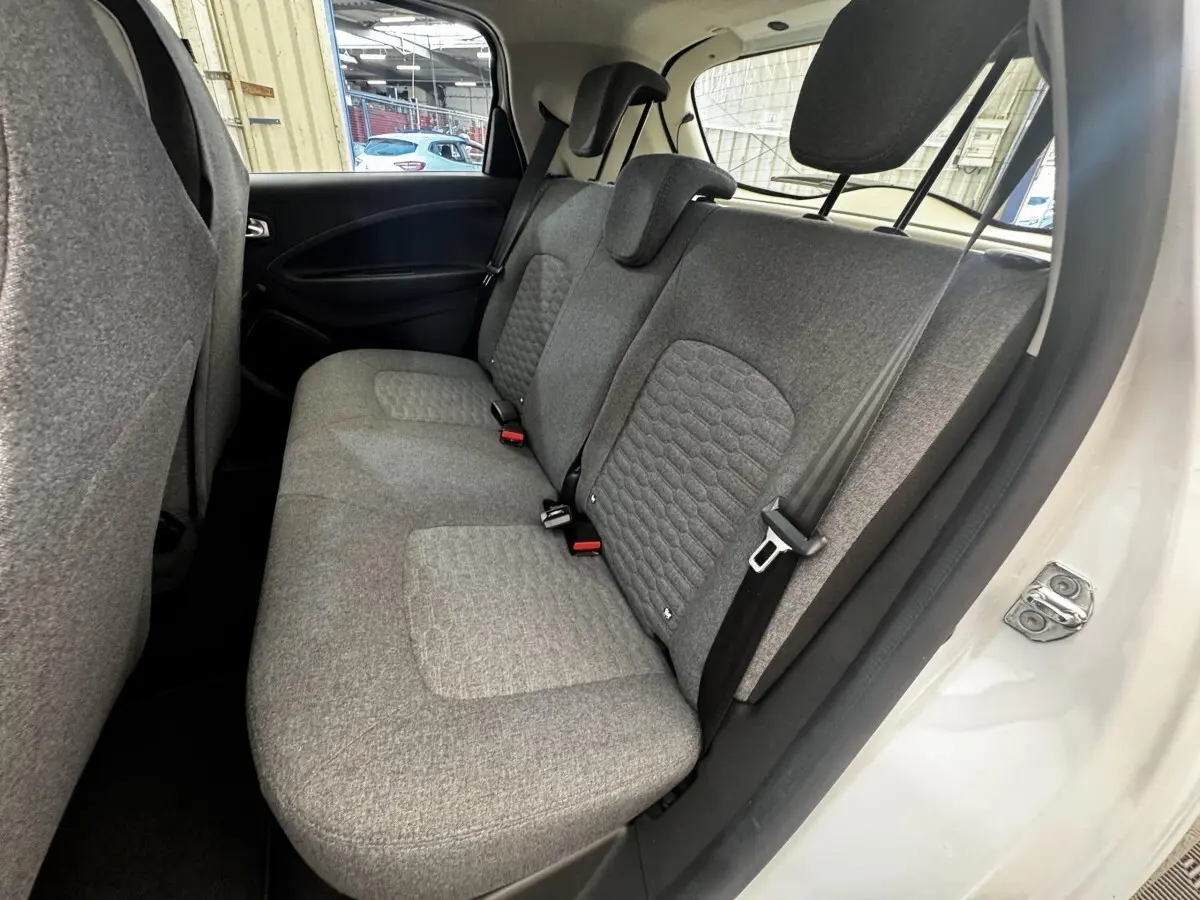 Vue côté droit sur la banquette arrière grise de la Renault ZOE blanche Iconic R135 2022, avec ceinture de sécurité visible.