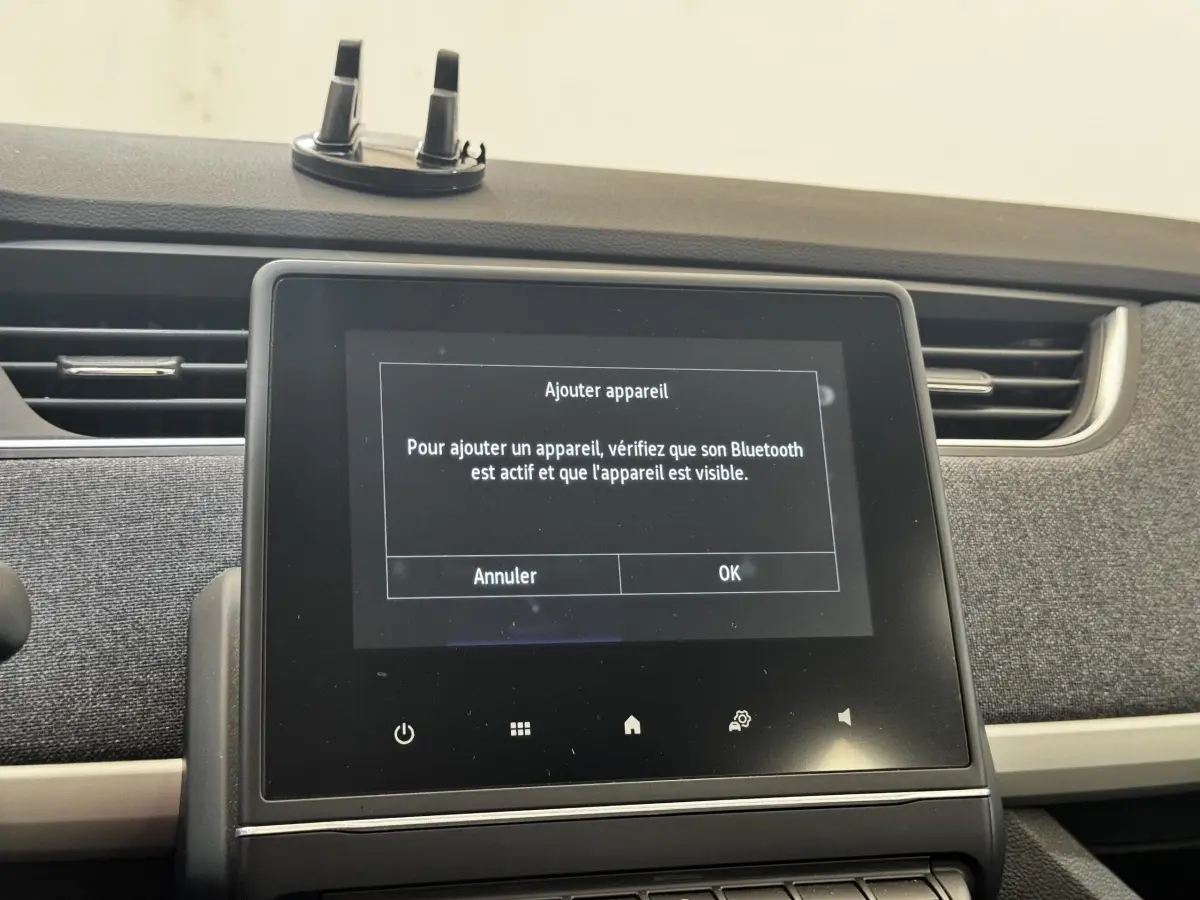 Écran tactile central de la Renault ZOE Iconic R135 blanc, vue intérieure frontale du tableau de bord.