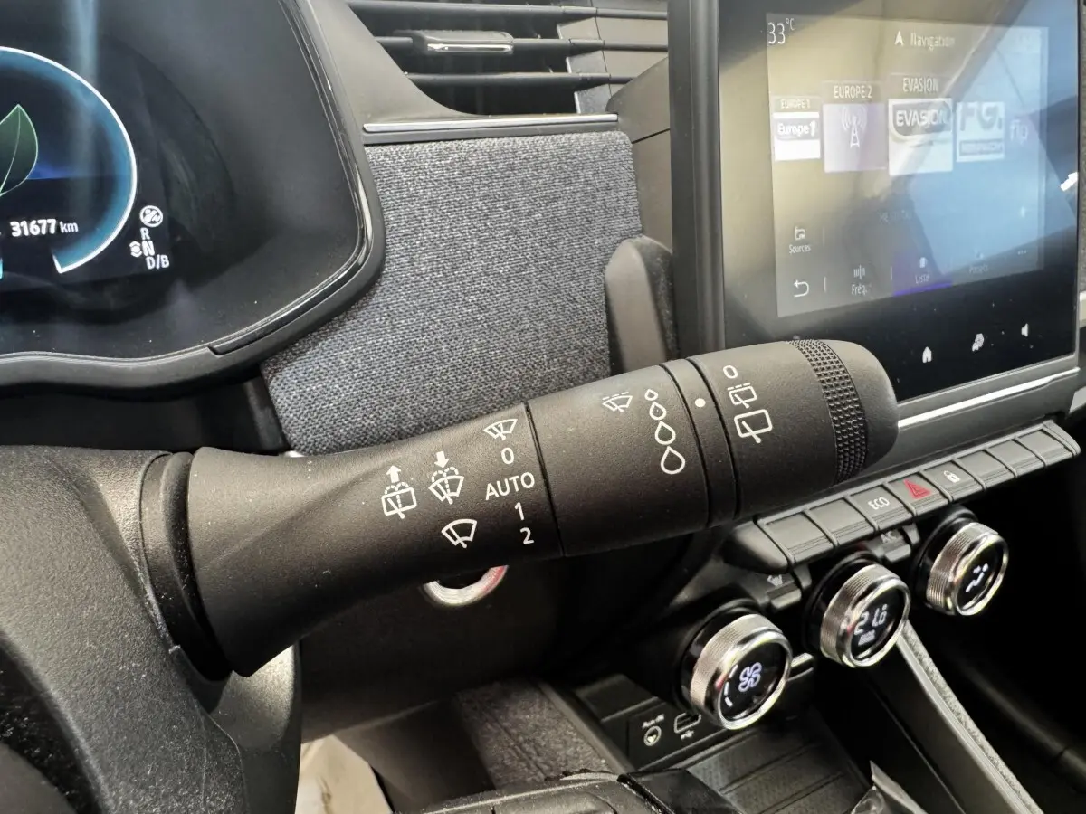 Gros plan sur la commande des essuie-glaces à gauche du volant dans l’habitacle de la Renault ZOE blanche Iconic R135 2022.