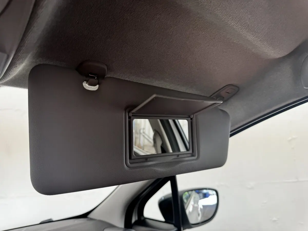 Détail intérieur du pare-soleil côté conducteur avec miroir rabattable dans une Renault ZOE blanche 2022.