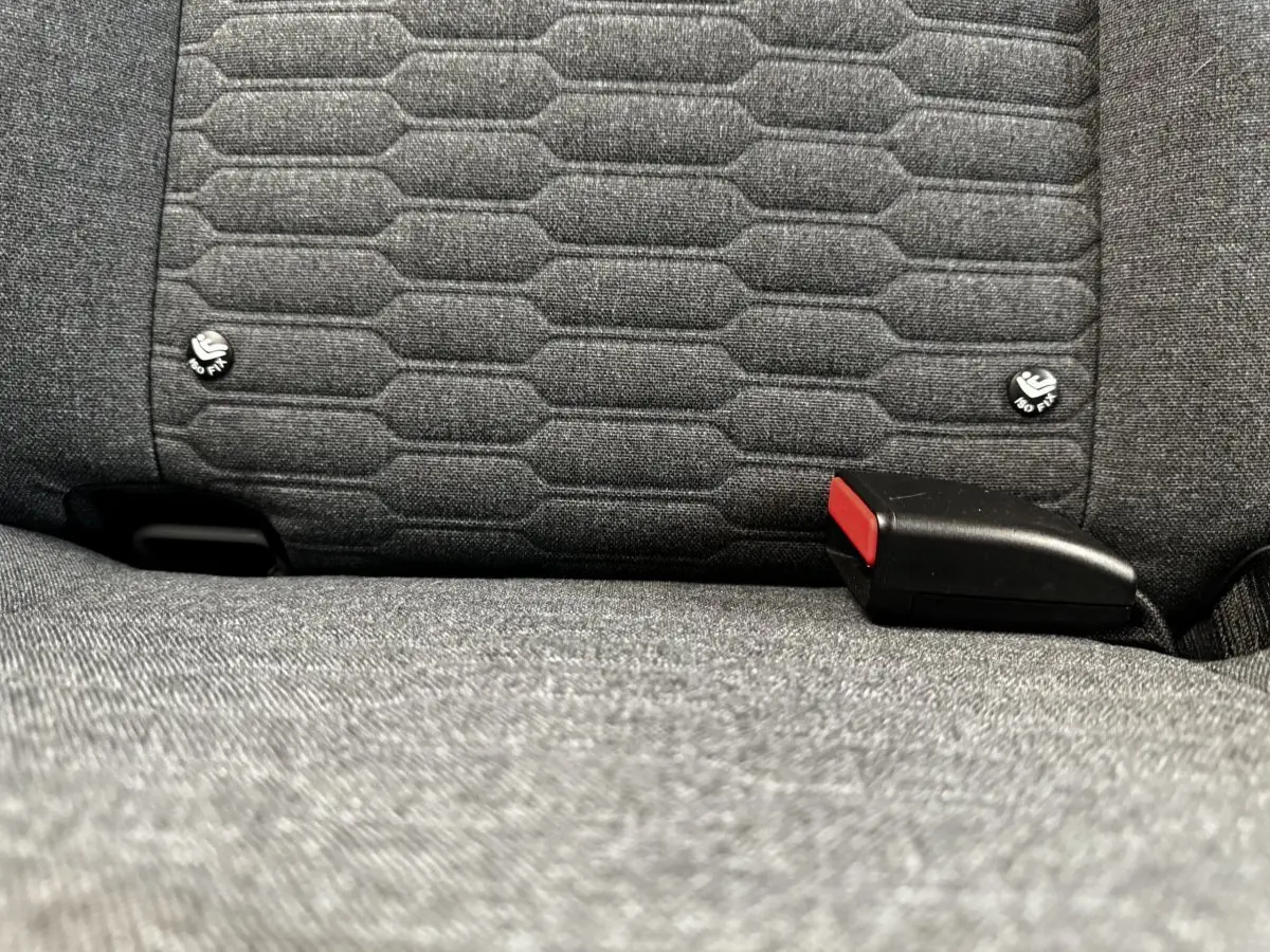 Gros plan sur la banquette arrière grise de la Renault ZOE Iconic R135, montrant les fixations ISOFIX et la boucle de ceinture.